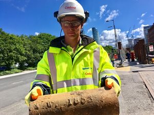 Cadent engineer holding an old gas pipe during street work.