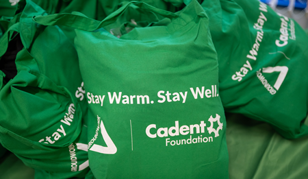 Green reusable bags printed with the words ‘Stay Warm. Stay Well.’ and the Cadent Foundation logo