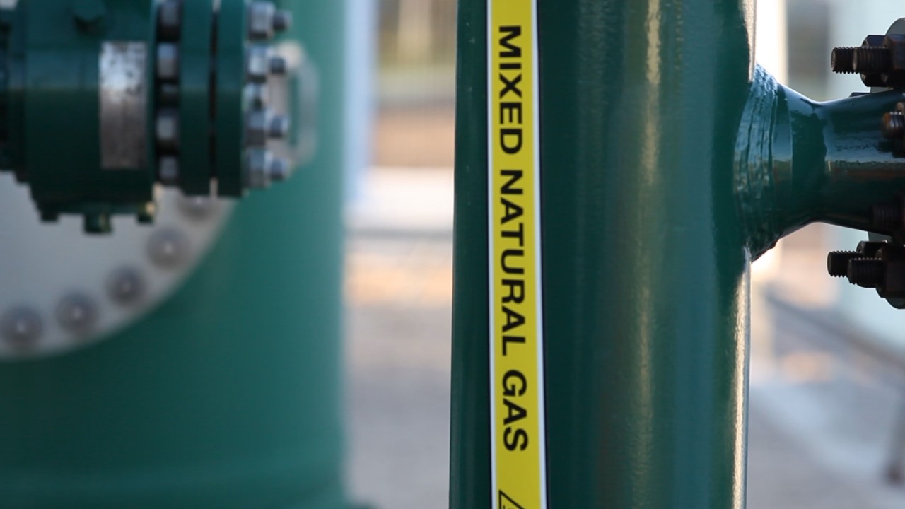Close-up of a green industrial gas pipe labelled “Mixed Natural Gas,” showing equipment used for blending hydrogen into the gas network.