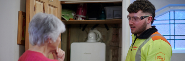 Cadent engineer explaining a boiler to a customer at home