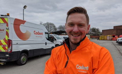 A smiling person in an orange 