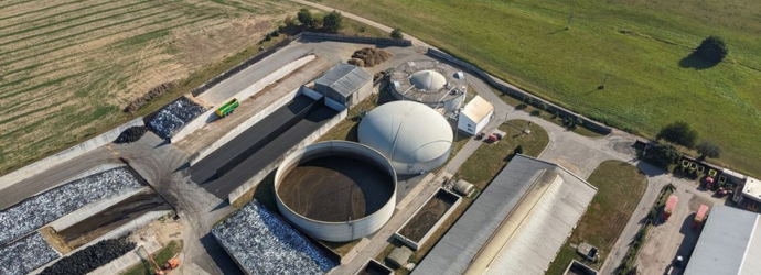 Aerial panorama landscape of biogas power plant and surrounding agricultural landscape showing biogas production, bioenergy generation, and green renewable electricity during the European energy crisis