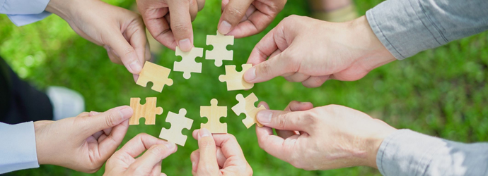 partnership, fitting together the pieces of environmental, social, and governance (ESG) strategies for sustainable success, symbolized by a jigsaw puzzle in hand.