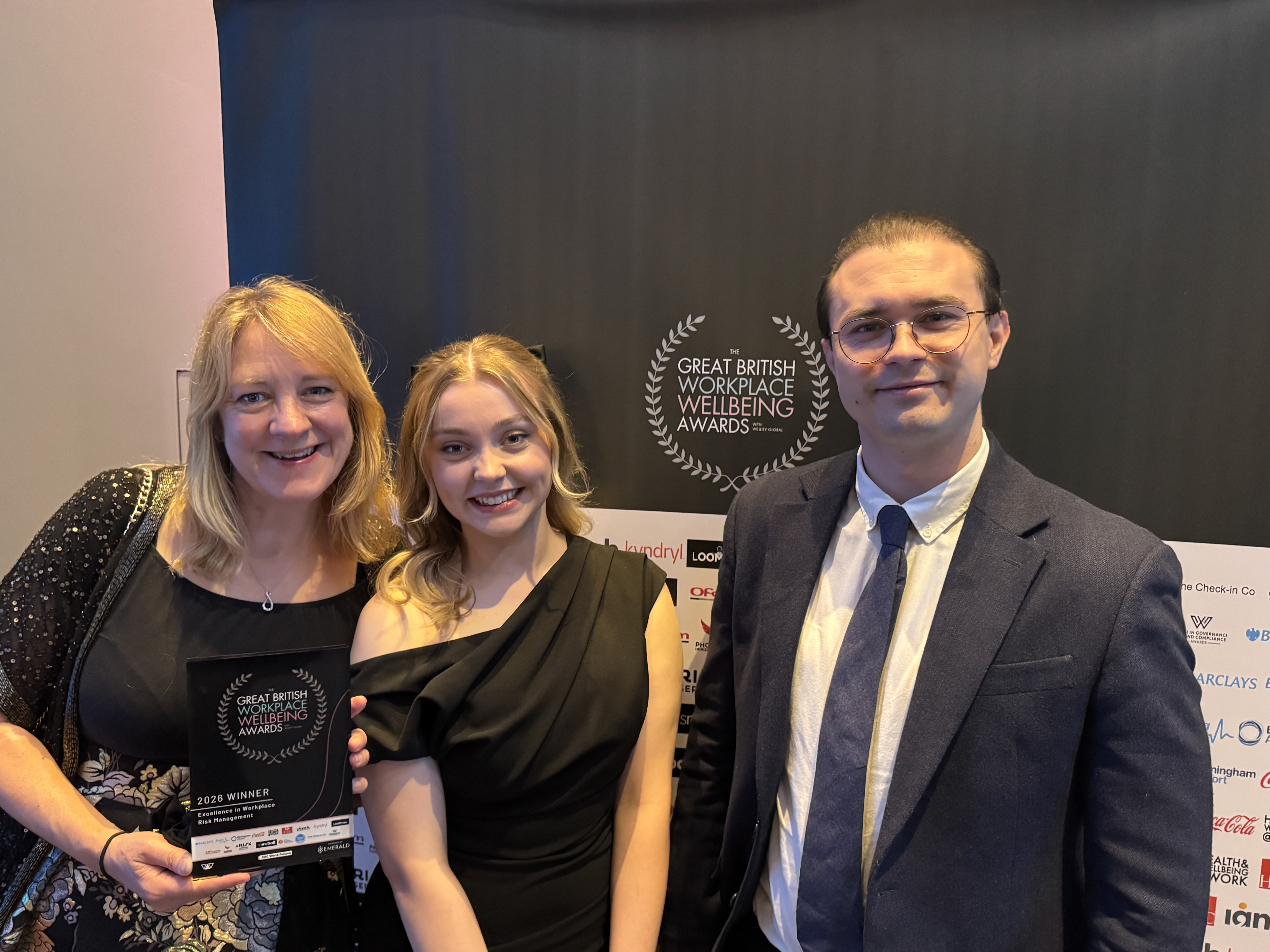 Cadent team receiving an award at The Great British Workplace Wellbeing Awards, standing in front of the event backdrop.