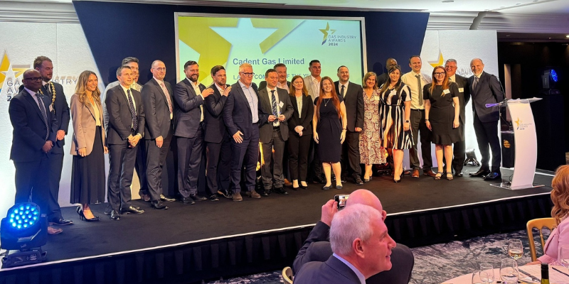 People standing and posing on a stage for a photoshoot on an award ceremony