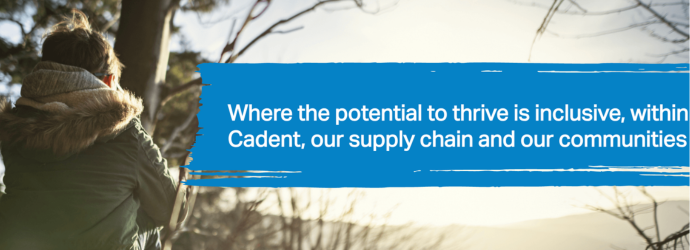 A person in a winter coat looks out at a sunlit landscape with trees. Blue text box says, Where the potential to thrive is inclusive, within Cadent, our supply chain and our communities.